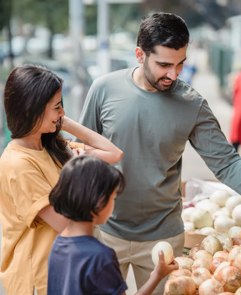 Familia escogiendo verduras en un mercado