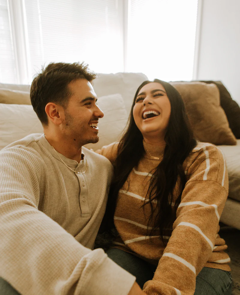 Pareja joven riéndose en casa